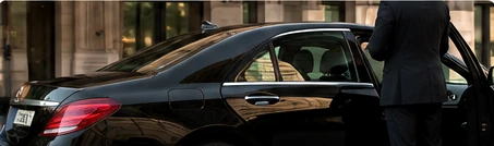 Private chauffeur beside a car